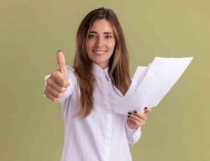 jpeg optimizer smiling young pretty caucasian girl holds blank paper sheets thumbs up isolated olive green wall with copy space 1
