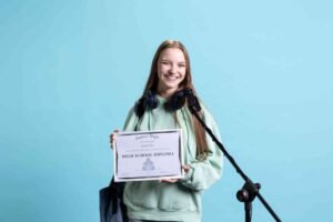 jpeg optimizer student holding diploma talking microphone addressing audience